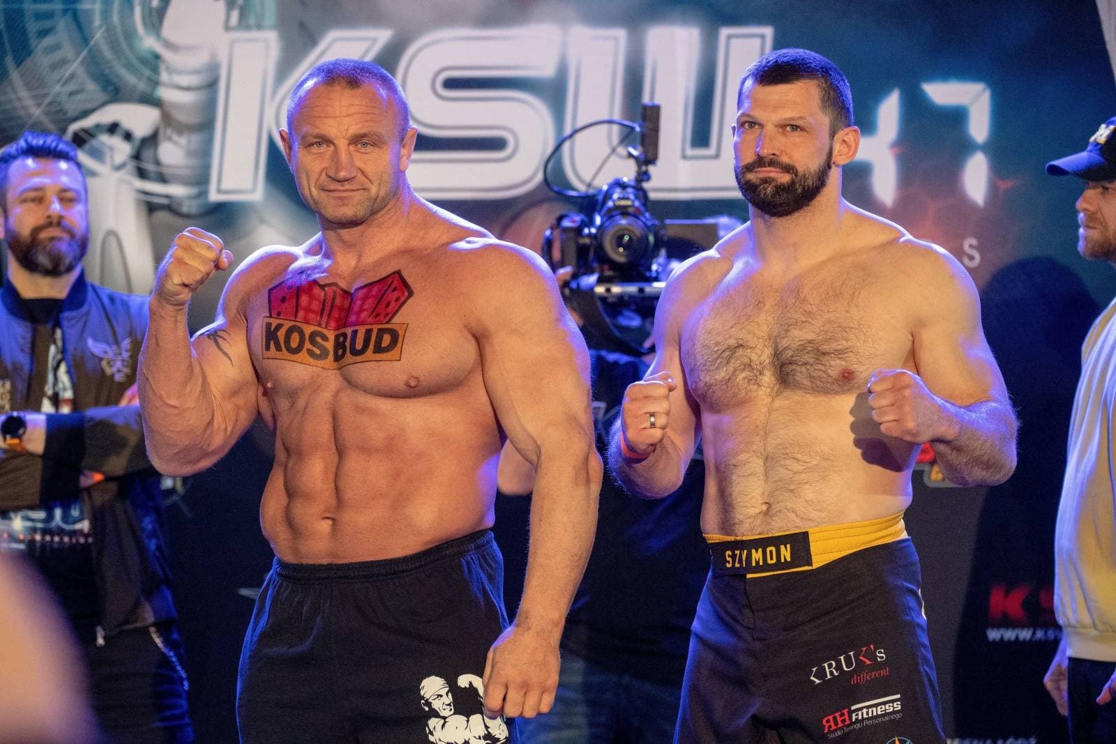 Ceremonia ważenia przed galą KSW, Szymon Kołecki i Mariusz Pudzianowski stoją naprzeciw kamer